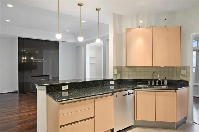 a kitchen with stainless steel appliances granite countertop a sink a refrigerator and a stove