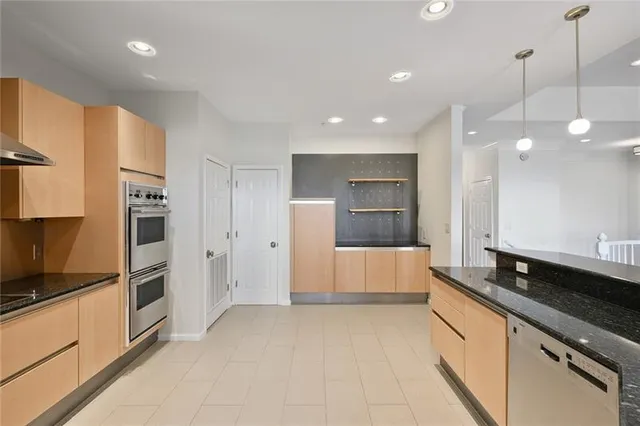 a large white kitchen with a refrigerator a sink and a stove