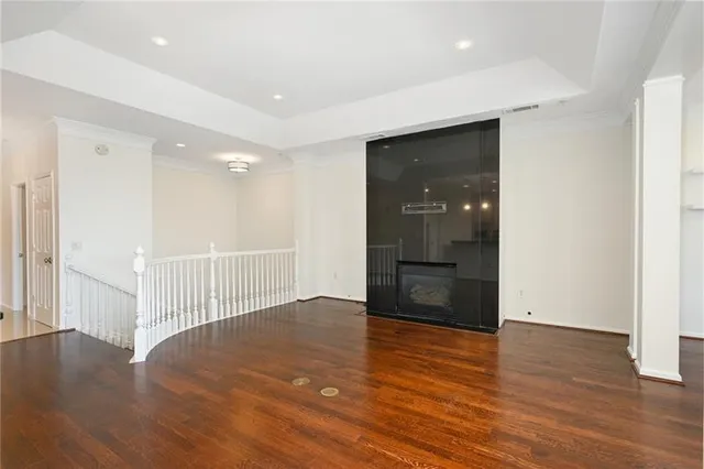 an empty room with wooden floor and entrance to ceiling window