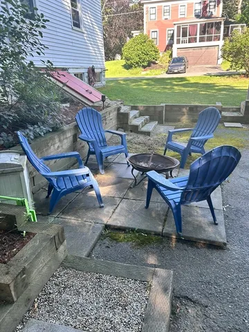 a view of a backyard with lawn chairs and a fire pit
