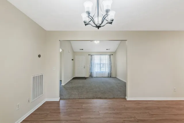 a view of a livingroom with wooden floor and a ceiling fan