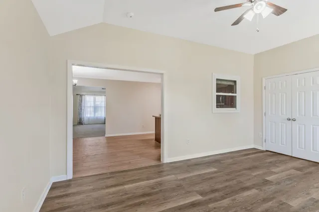 a view of a livingroom with wooden floor and a ceiling fan