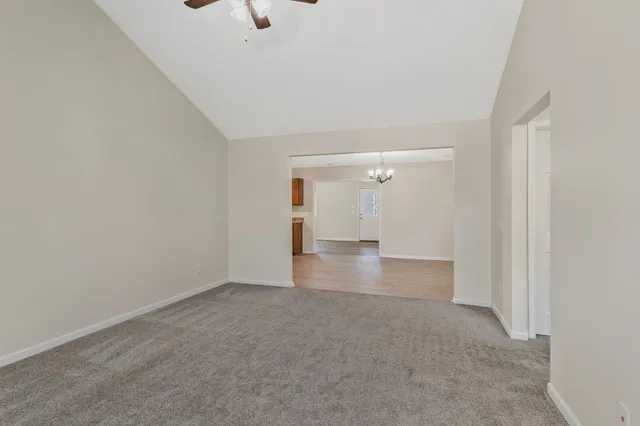 a view of a big room with wooden floor and windows