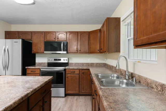 a kitchen with stainless steel appliances granite countertop a sink stove and refrigerator