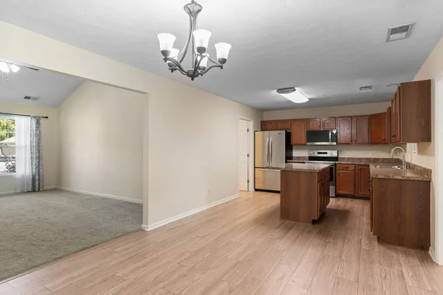 a view of kitchen with granite countertop microwave and cabinets