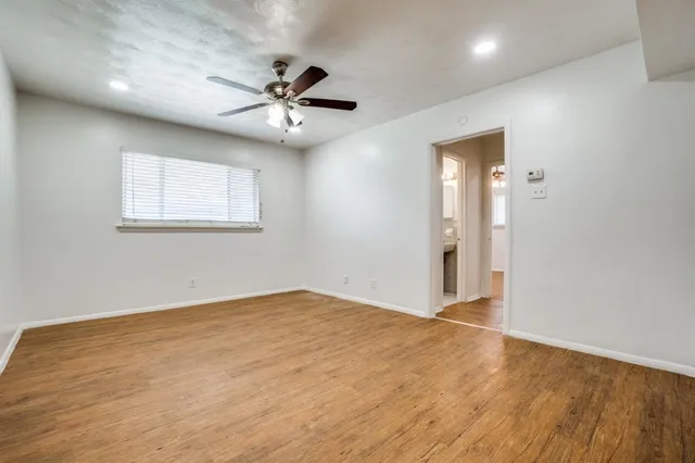 an empty room with fan and windows