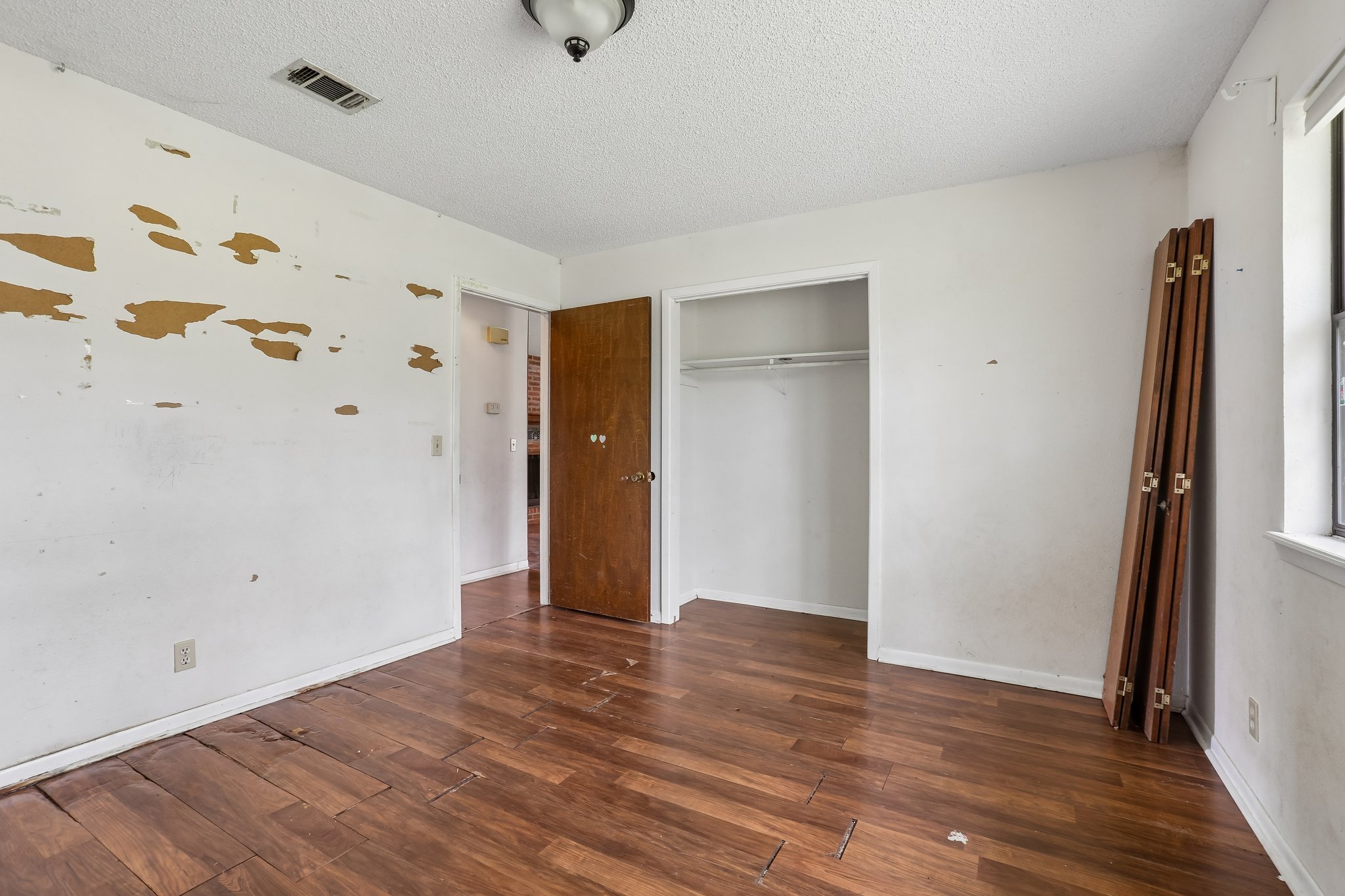 406 Monkey Road Elgin, TX 78621 - Photo 21 of 39 Spacious room featuring wood-finish flooring, a built-in closet with shelving and hanging rod, a ceiling light fixture, and a window