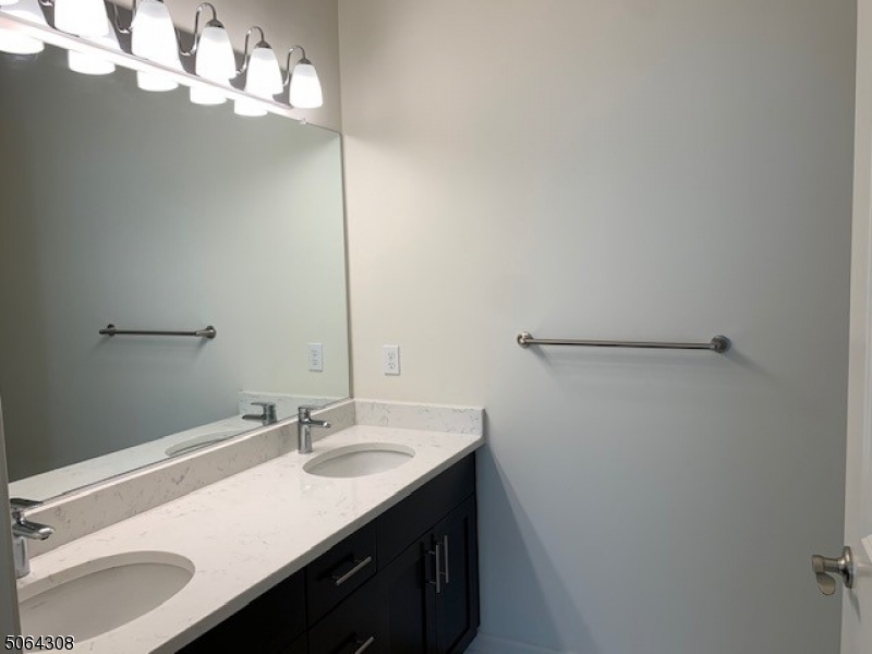 60 Passaic Avenue, Unit 20 Fairfield, NJ 07004 - Photo 11 of 13 a bathroom with a sink vanity and a mirror