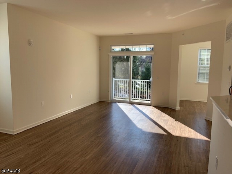 60 Passaic Avenue, Unit 20 Fairfield, NJ 07004 - Photo 3 of 13 an empty room with wooden floor and windows