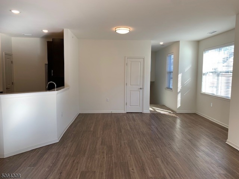 60 Passaic Avenue, Unit 20 Fairfield, NJ 07004 - Photo 4 of 13 an empty room with wooden floor and windows