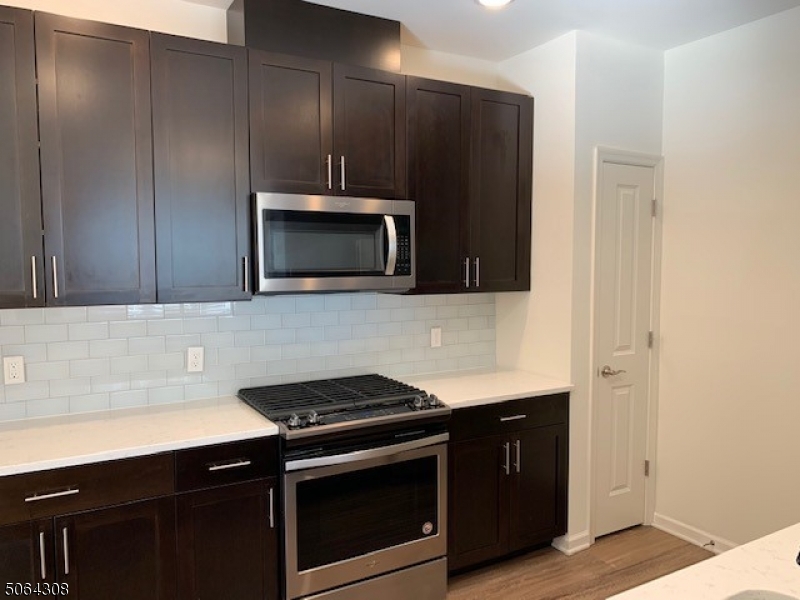 60 Passaic Avenue, Unit 20 Fairfield, NJ 07004 - Photo 5 of 13 a kitchen with a sink stove and microwave