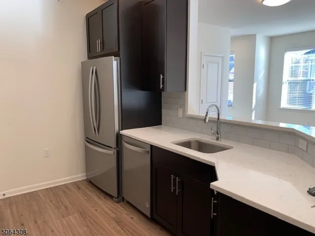 a kitchen with kitchen island granite countertop a sink and a refrigerator