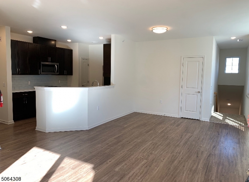 60 Passaic Avenue, Unit 20 Fairfield, NJ 07004 - Photo 8 of 13 a view of an empty room with kitchen view and a window