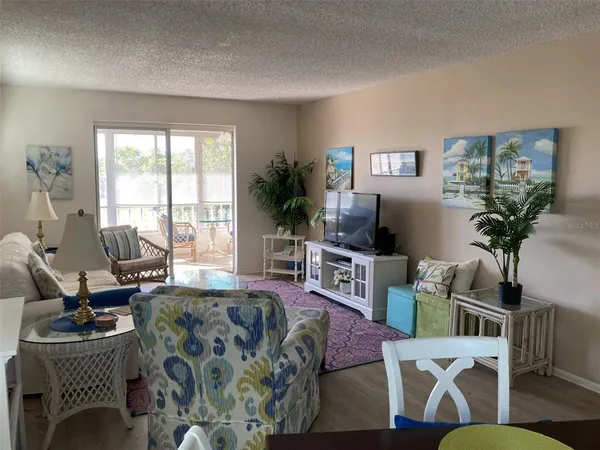 a living room with furniture a flat screen tv and a large window