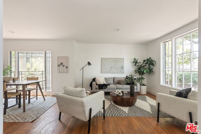 a living room with furniture a large window and a wooden floor