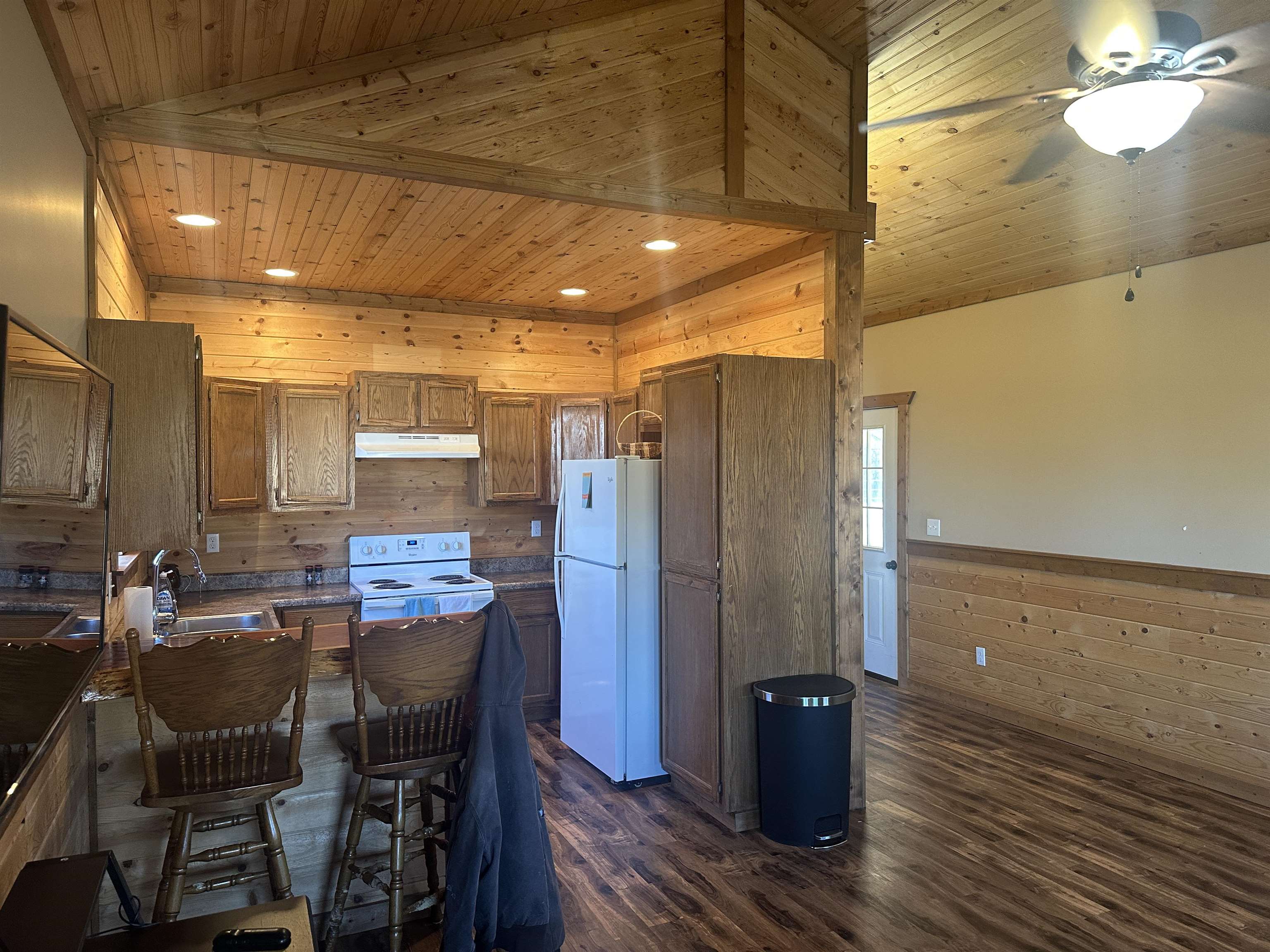 2245 Fritton Spur Road Middleton, TN 38052 - Photo 14 of 24 Kitchen with wood walls, a wainscoted wall, wood ceiling, dark countertops, and white appliances