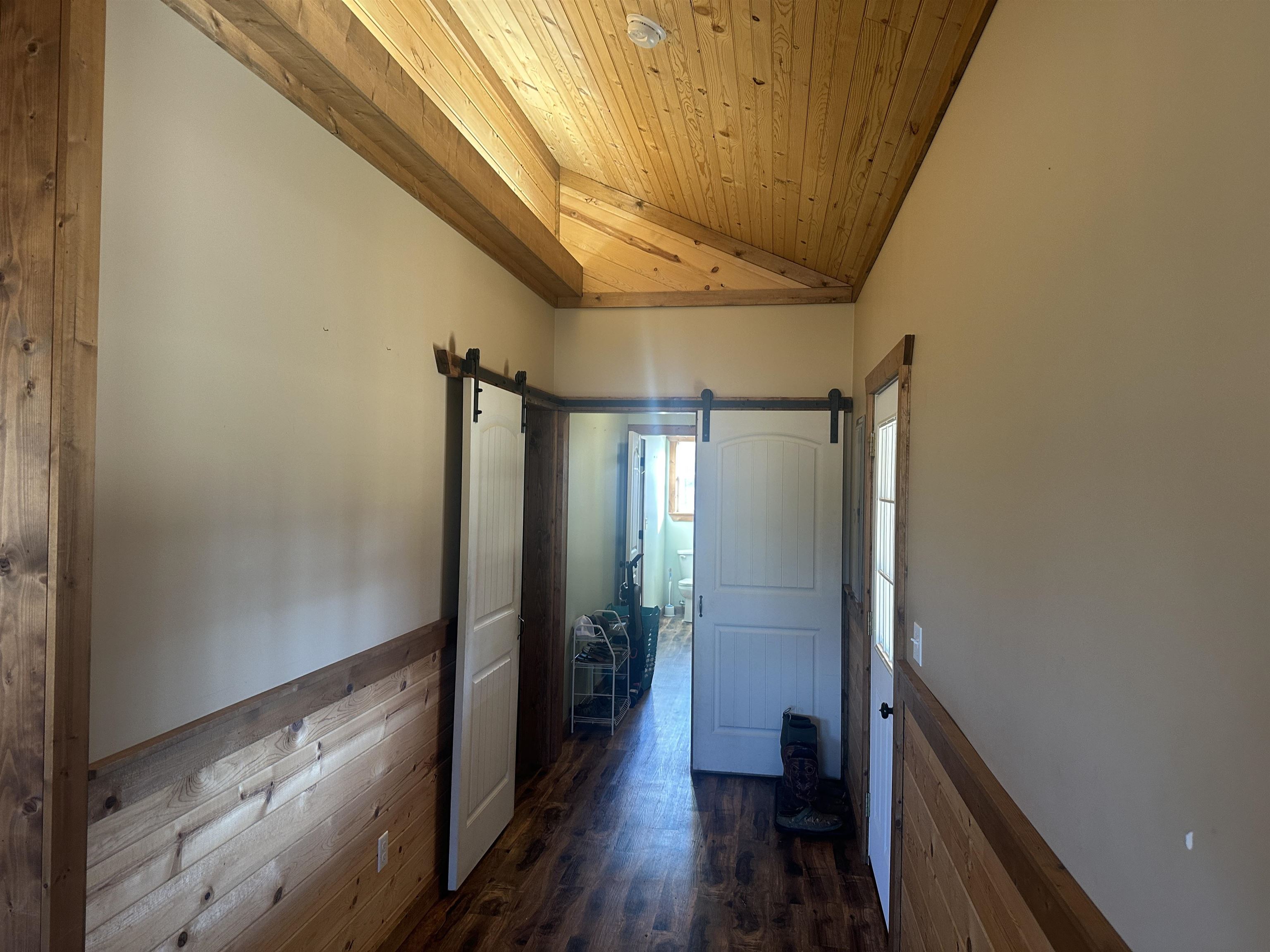 2245 Fritton Spur Road Middleton, TN 38052 - Photo 17 of 24 Corridor with a barn door, wood ceiling, dark wood-style flooring, vaulted ceiling, and wainscoting