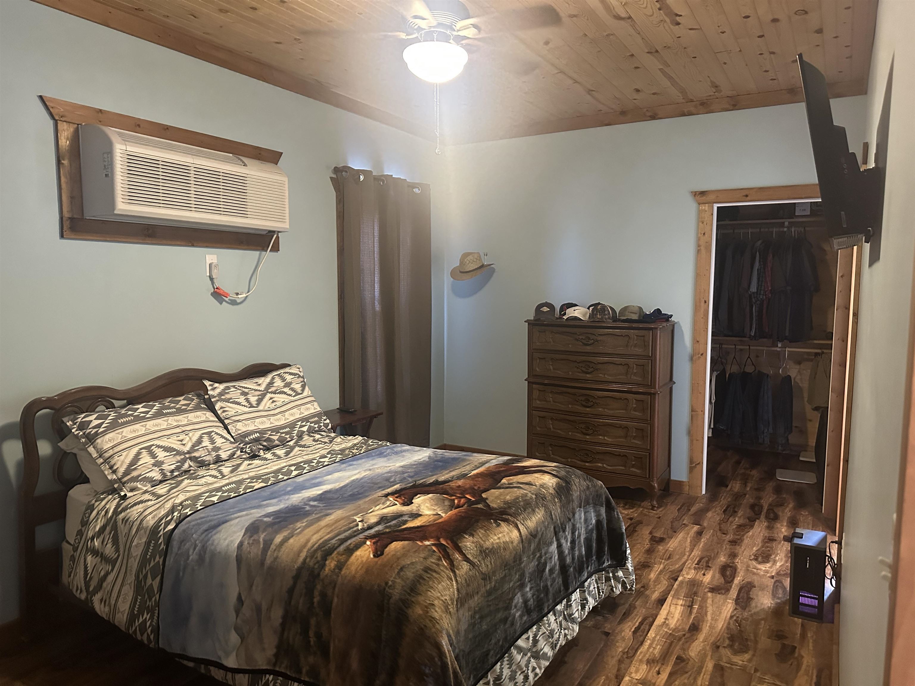 2245 Fritton Spur Road Middleton, TN 38052 - Photo 19 of 24 Bedroom with wood ceiling, dark wood-style floors, a wall unit AC, a spacious closet, and a ceiling fan