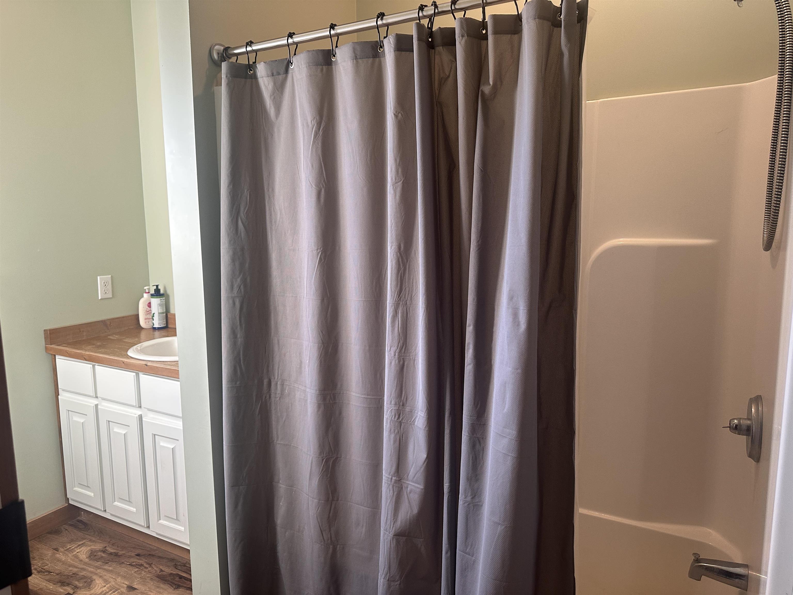 2245 Fritton Spur Road Middleton, TN 38052 - Photo 23 of 24 Bathroom featuring vanity, dark wood-type flooring, and shower / tub combo