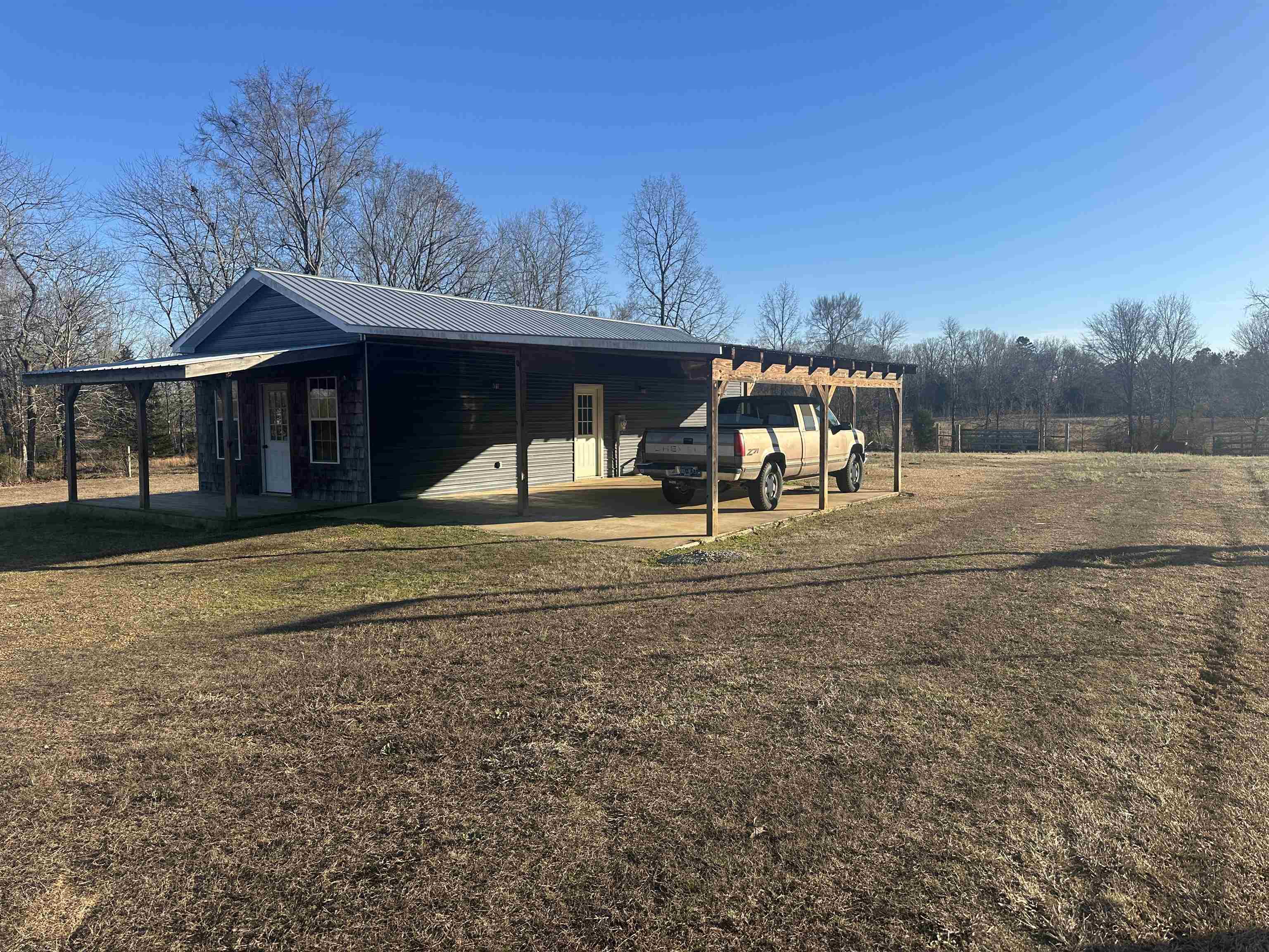2245 Fritton Spur Road Middleton, TN 38052 - Photo 6 of 24 View of home's exterior featuring an attached carport, a metal roof, a lawn, and covered porch