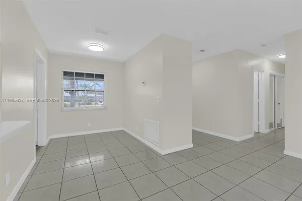 an empty room with white walls and view of bathroom