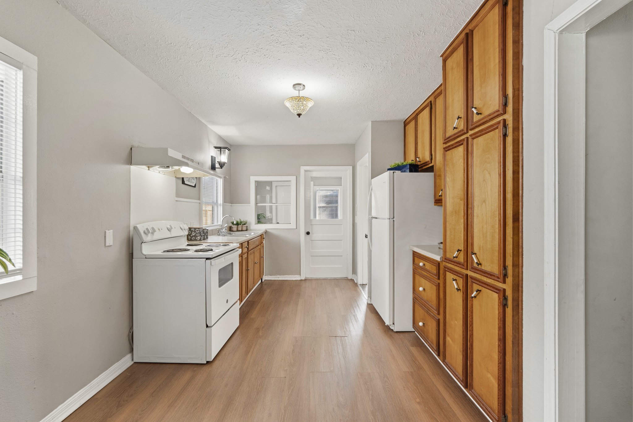 1509 Mulcahy Street Rosenberg, TX 77471 - Photo 12 of 41 a kitchen with granite countertop a refrigerator a sink dishwasher a stove and a dining table with wooden floor