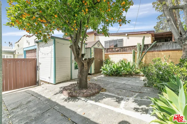 a front view of a house with a yard and tree