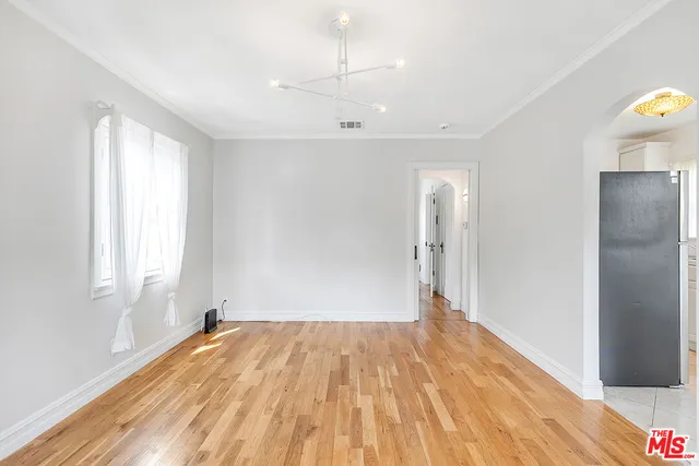 a view of a room with wooden floor and a ceiling fan