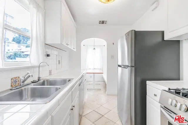 a kitchen with stainless steel appliances granite countertop a refrigerator and a sink