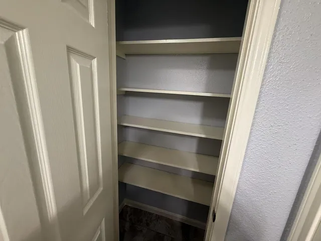 a view of walk in closet with empty racks