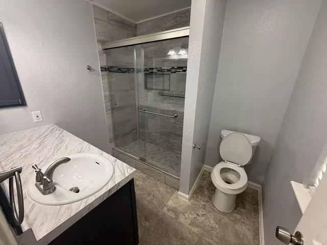 a bathroom with a sink toilet and shower