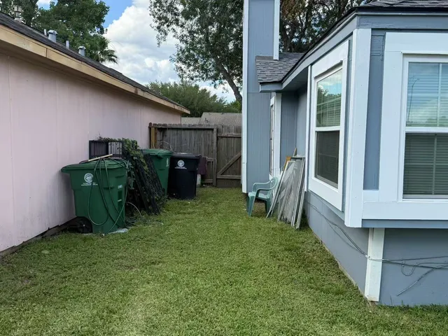 a view of backyard with barbeque grill and a large tree