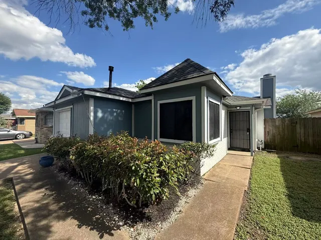 a front view of house with yard and trees around