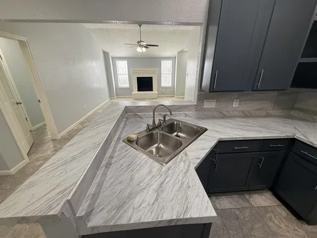 a kitchen with stainless steel appliances granite countertop a sink dishwasher stove and refrigerator