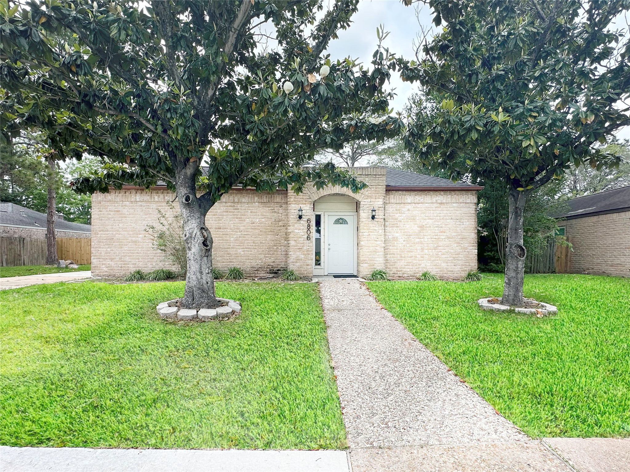 a front view of house with a garden