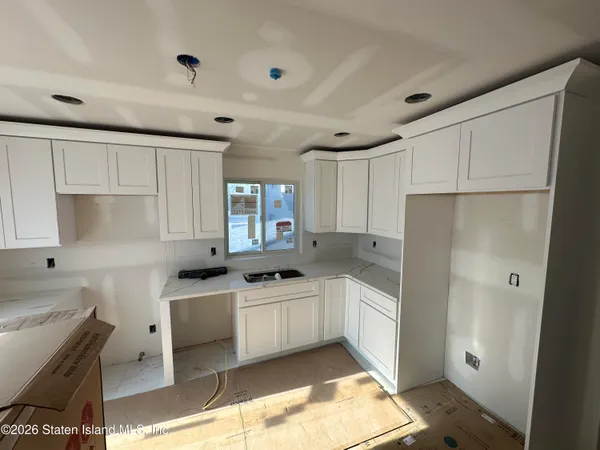a kitchen with white cabinets and white appliances