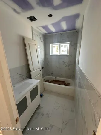 a bathroom with a tub a sink and a mirror