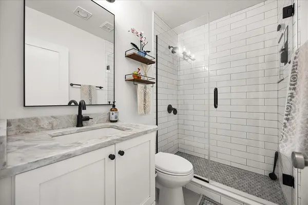 a bathroom with a sink a toilet and shower