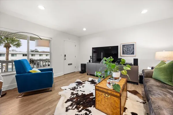 a living room with furniture potted plant and a flat screen tv