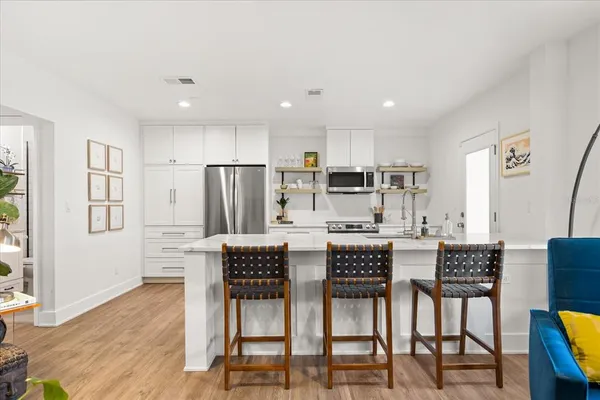 a dining area with stainless steel appliances kitchen island granite countertop a dining table chairs and granite counter tops