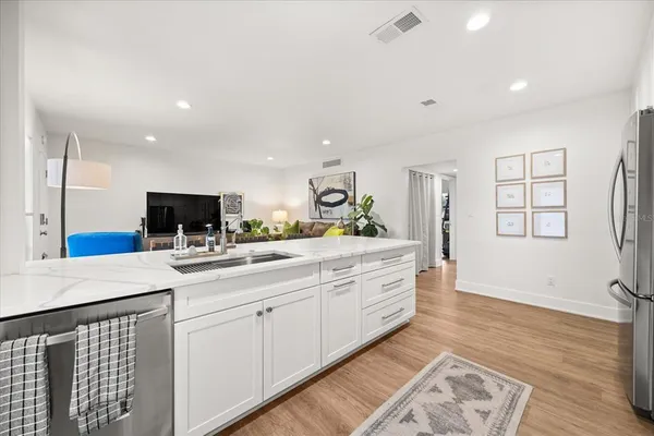 a kitchen with white cabinets and sink
