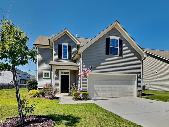 a front view of a house with yard and green space