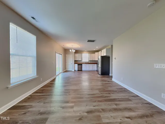 a view of empty room with wooden floor