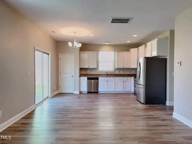 a view of kitchen with refrigerator stove microwave and cabinets