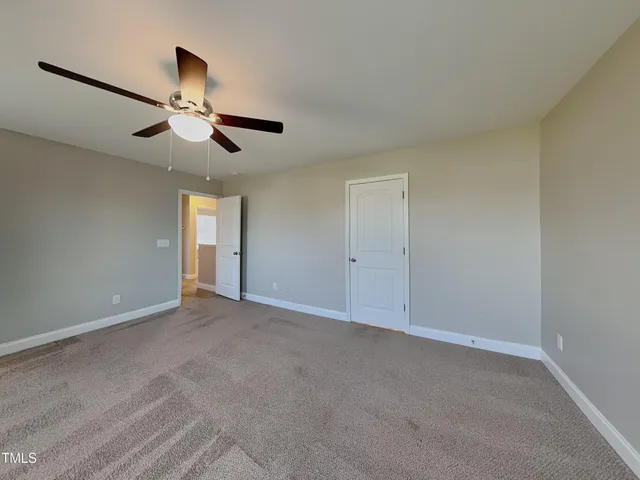 a view of an empty room with a ceiling fan