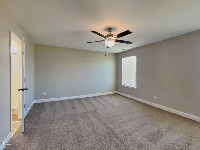 an empty room with a ceiling fan and a window