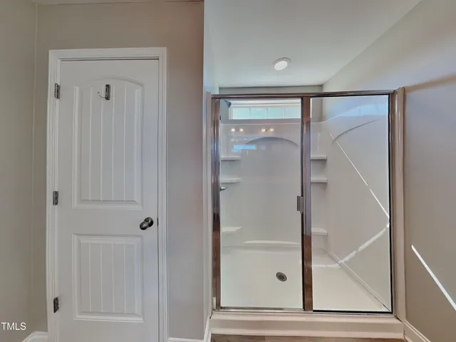 a view of a hallway with wooden floor and closet area