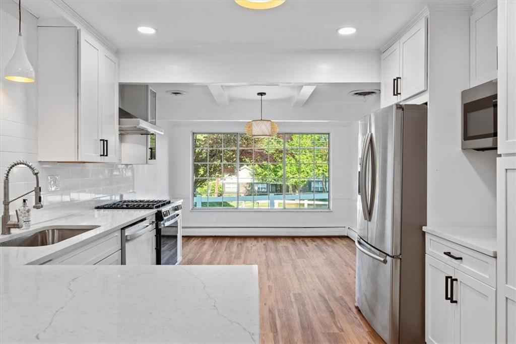 233 Sunset Drive Pittsburgh, PA 15235 - Photo 17 of 48 a kitchen with stainless steel appliances granite countertop a refrigerator a sink a stove and white cabinets with wooden floor