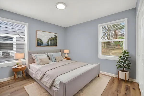 a bedroom with a large bed and a potted plant