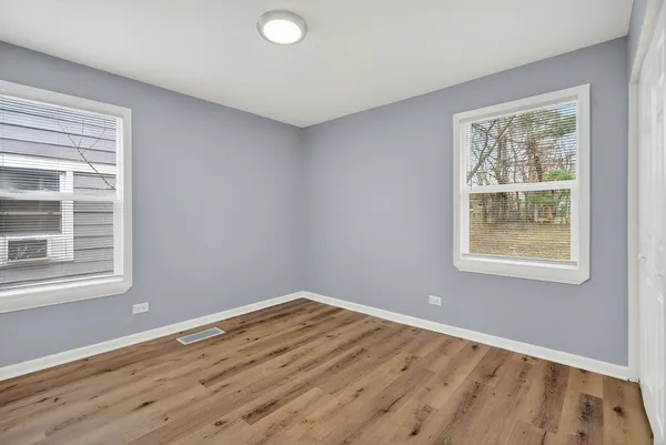 a view of a room with wooden floor and windows
